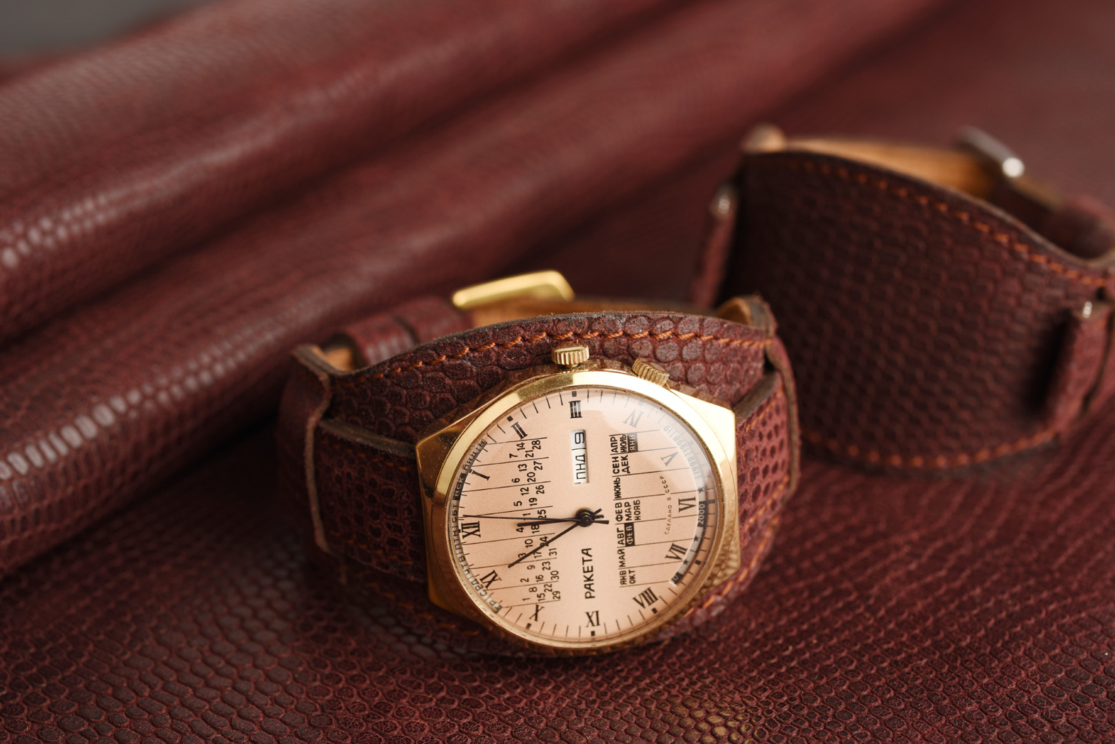 Kožený remienok s podložkou, imitácia jašterice v bordovo-hnedom odtieni s medeným prešívaním.